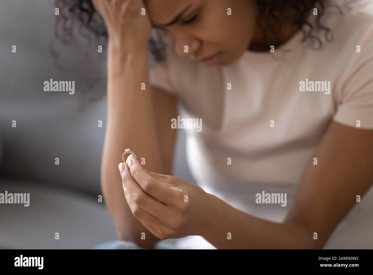 Primo piano vista infelice donna africana che tiene anello di nozze Foto Stock