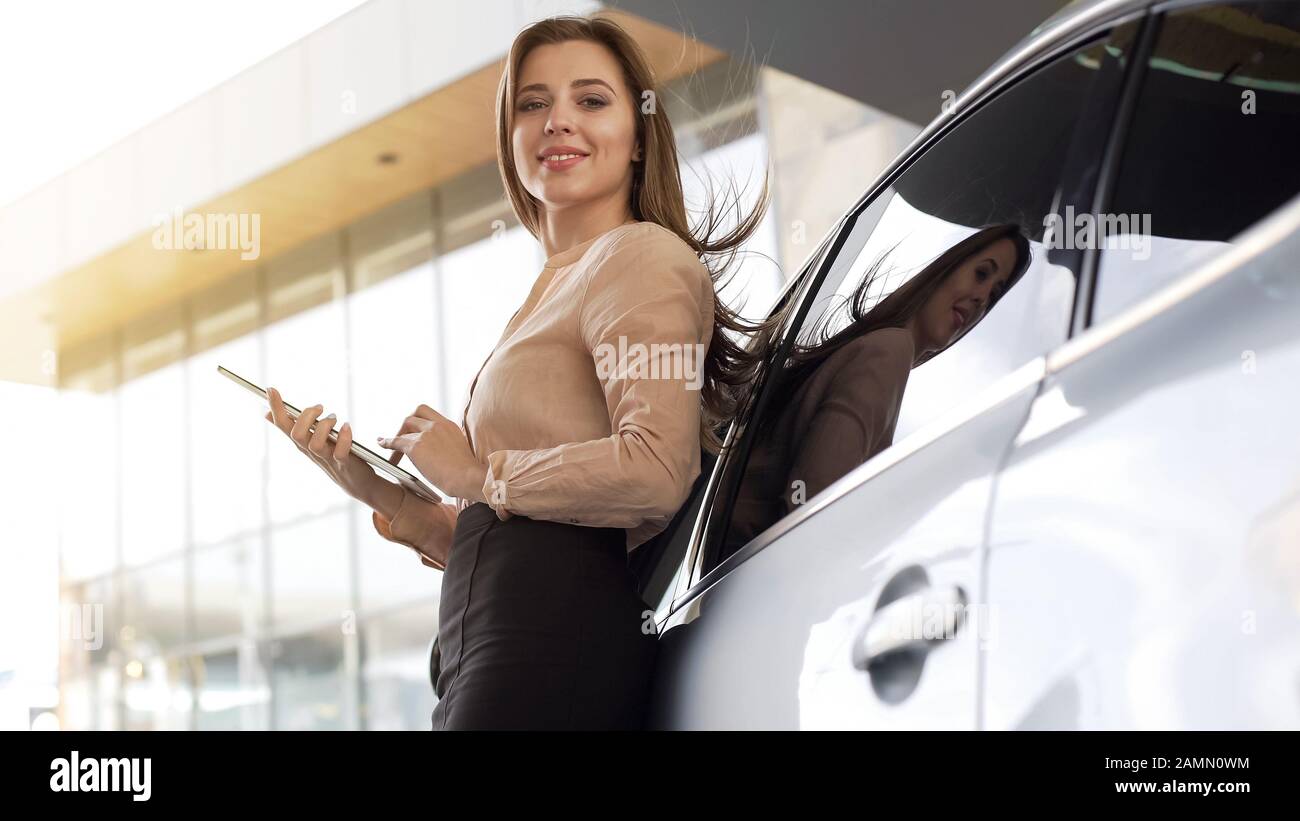 Dirigente professionale femminile con tablet in piedi vicino all'auto presso l'edificio degli uffici Foto Stock