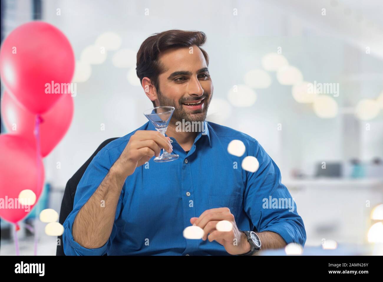 Giovane uomo che beve un drink al suo gruppo di lavoro. Foto Stock