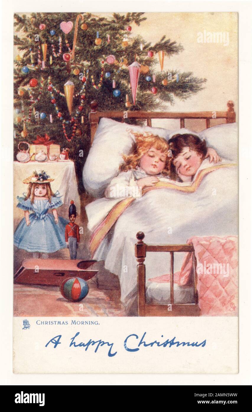 Originale carino tradizionale auguri di Natale cartolina di bambini rimboccato a letto la mattina di Natale con regali e albero, originale oilette, circa 1905, Inghilterra, Regno Unito Foto Stock