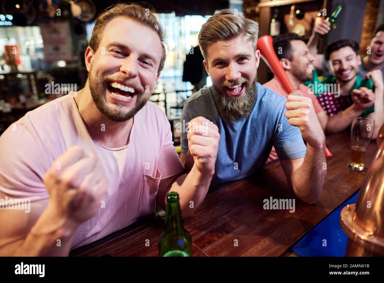 Giovani amici uomini adulti che rallegrano la squadra di calcio Foto Stock