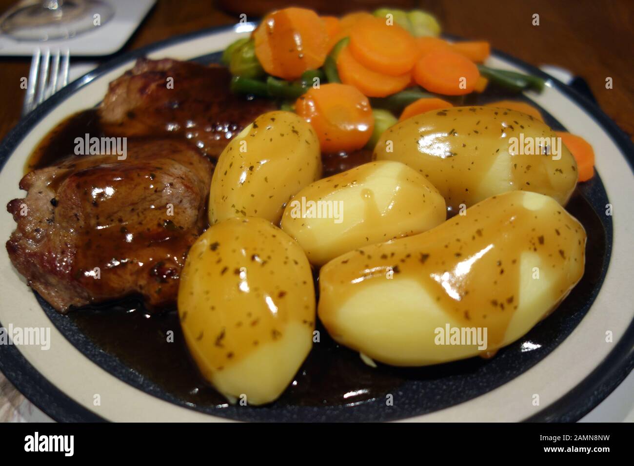 Piastra di in casa la carne di agnello in padella, patate lesse e verdure coperto in salsa di menta. Foto Stock