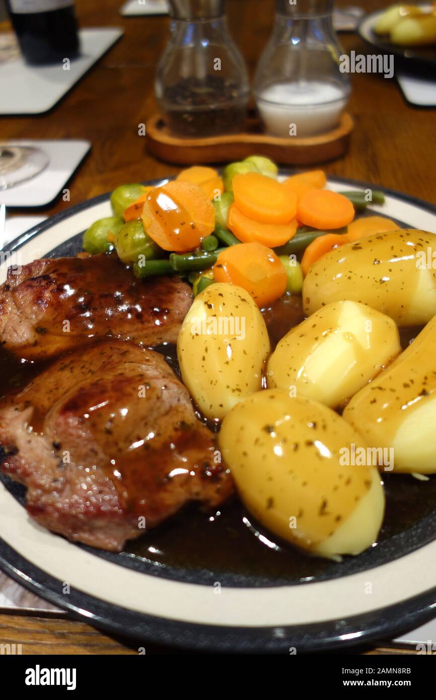 Piastra di in casa la carne di agnello in padella, patate lesse e verdure coperto in salsa di menta. Foto Stock