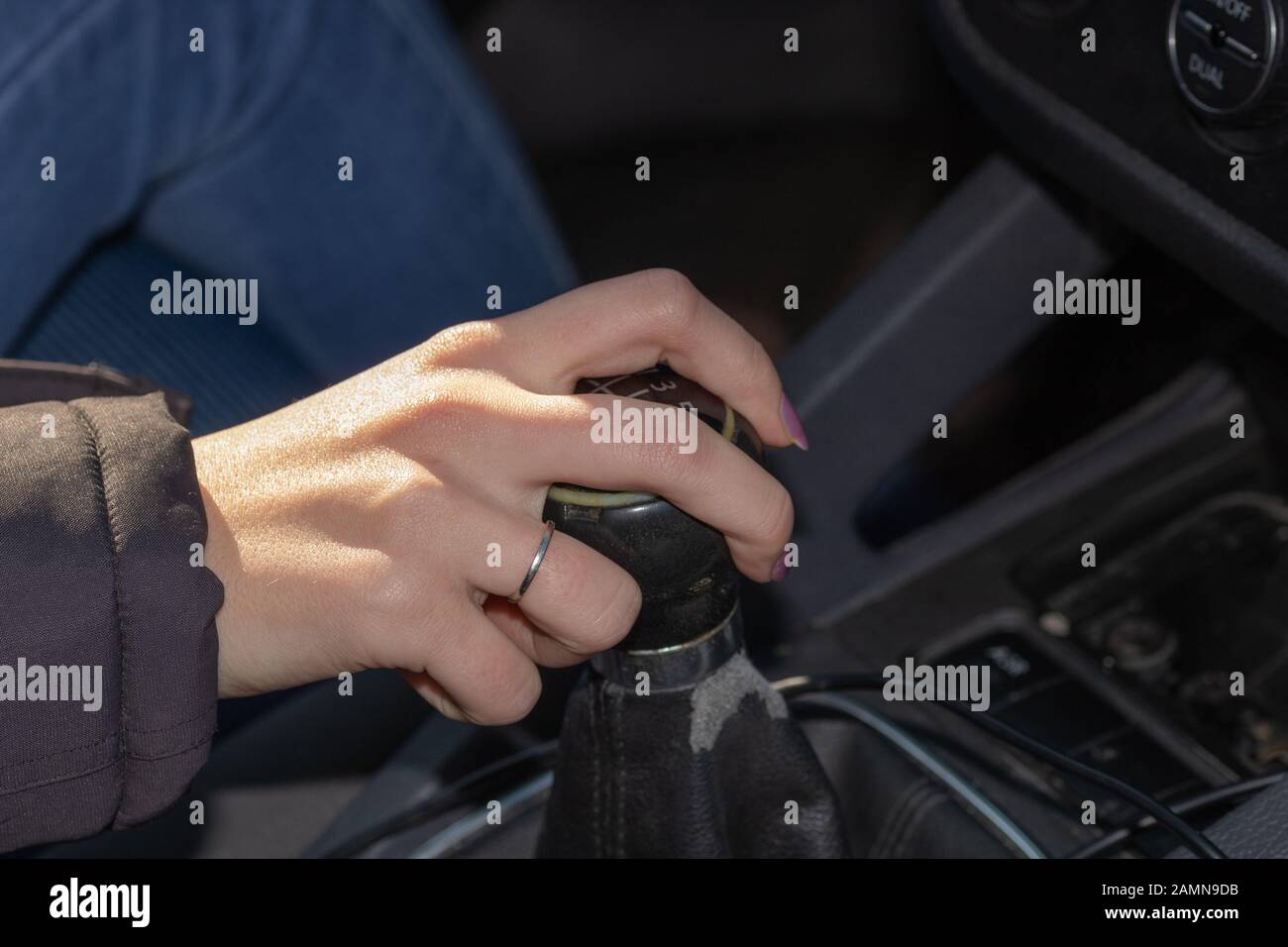 Primo piano di una mano da donna sul cambio marcia mentre si guida la vettura. Foto Stock