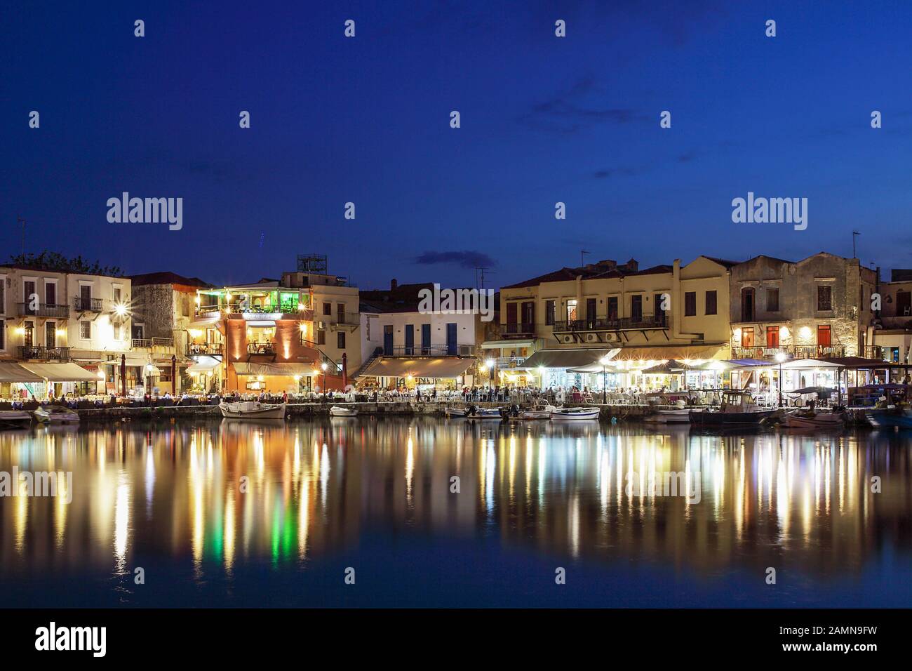 Il porto veneziano di Rethymnon Creta, visto qui in una bella serata all'inizio dell'estate con i suoi ristoranti tradizionali. Foto Stock