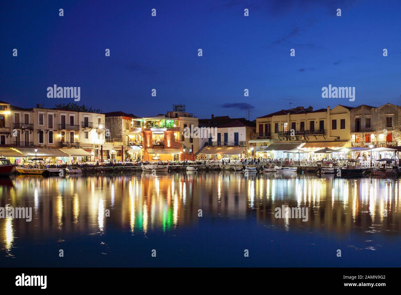 Il porto veneziano di Rethymnon Creta, visto qui in una bella serata all'inizio dell'estate con i suoi ristoranti tradizionali. Foto Stock