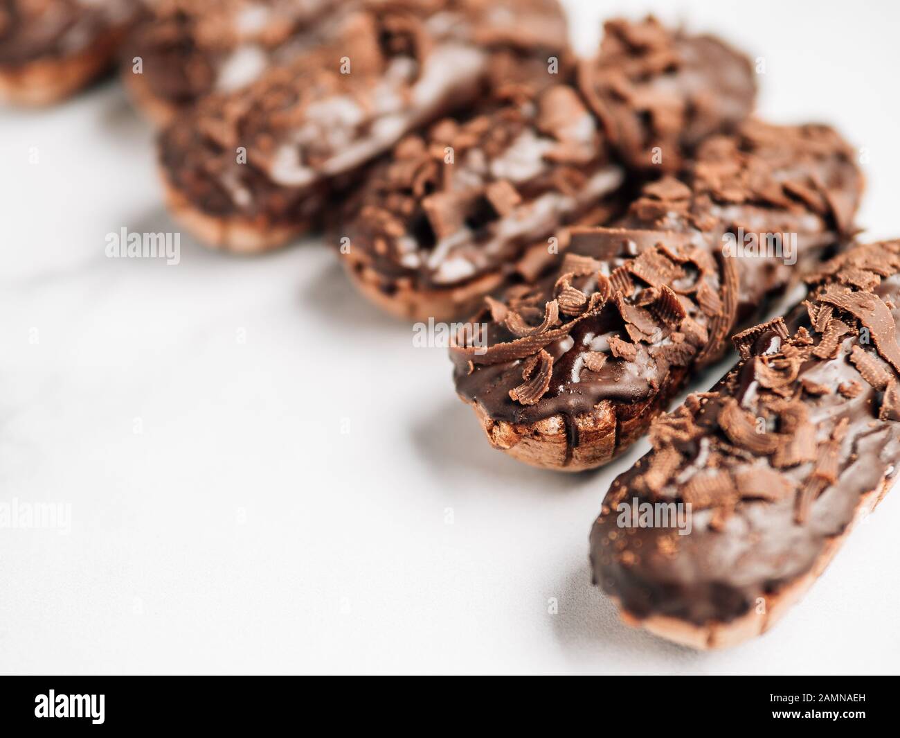 Set di eclairs fatti in casa con cioccolato su sfondo marmo. Vista ravvicinata della deliziosa profitroles sani con glassa di cioccolato. Copia spazio per il testo o per la progettazione Foto Stock