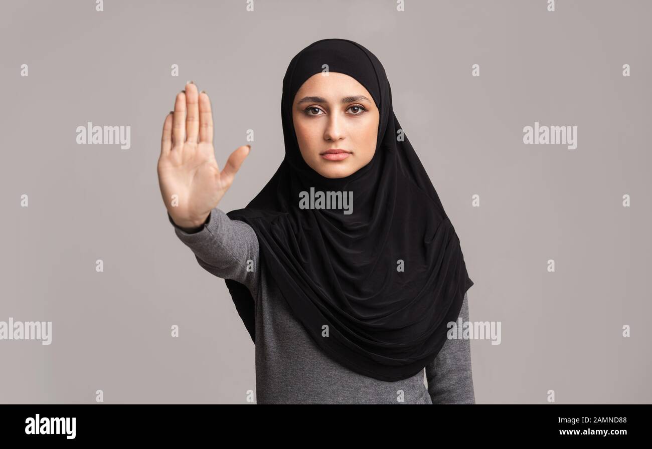 Donna musulmana in hijab fare il gesto di arresto con la sua mano Foto Stock