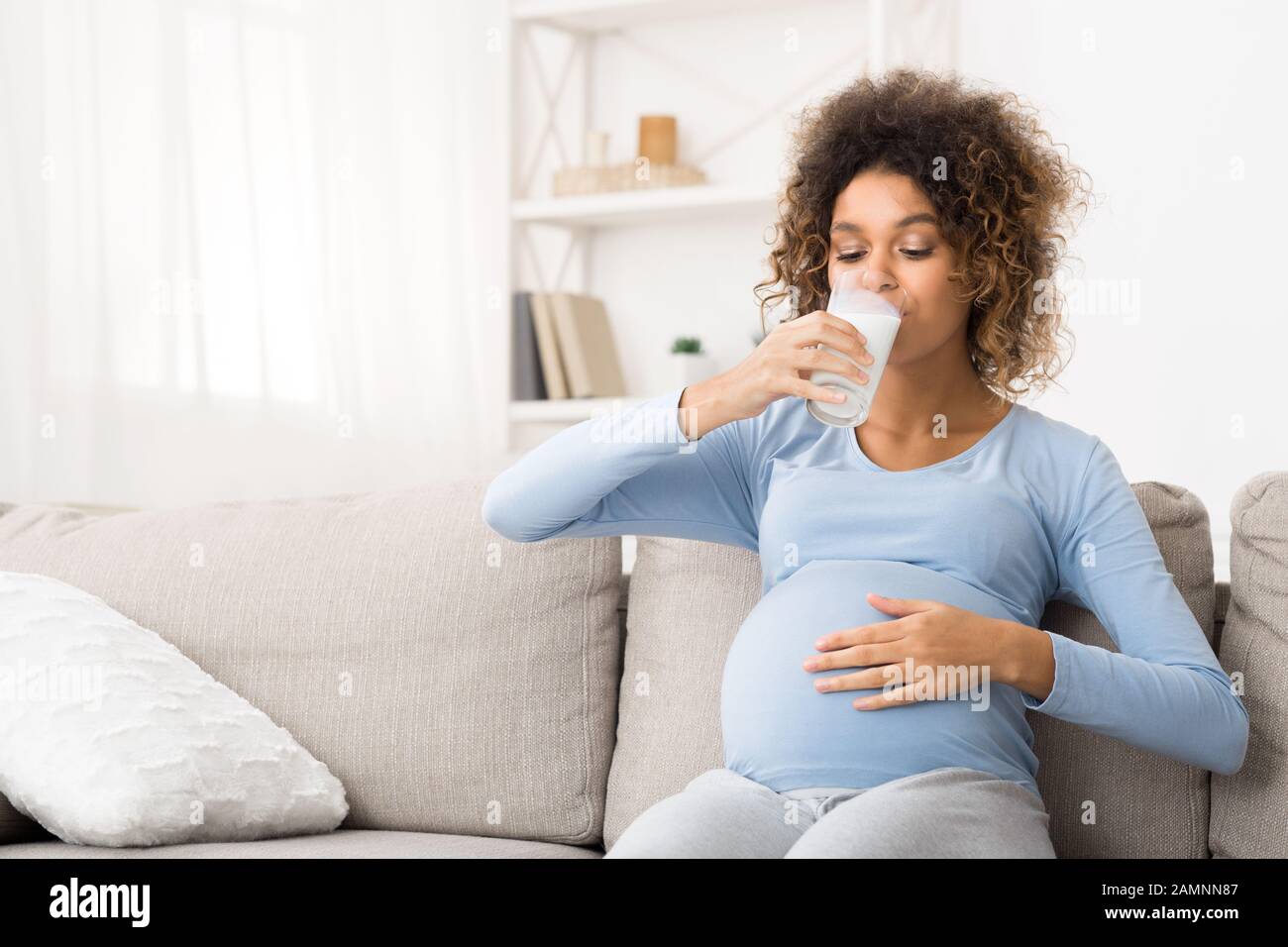 Dieta utile per gravidanza. Afro donna incinta bere latte Foto Stock