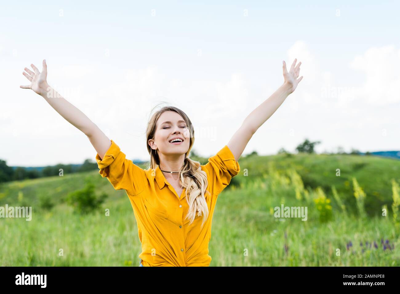 giovane donna felice con mani tese e occhi chiusi Foto Stock