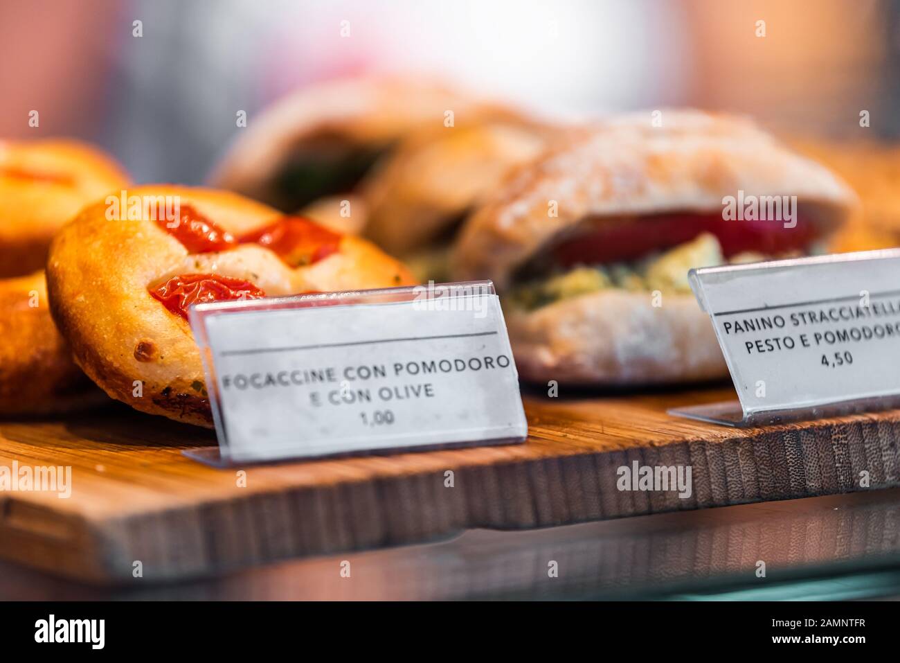 Ristorante panetteria esposizione primo piano di pane foccacia con pomodori e olio d'oliva e panini panino per pranzo in negozio a Firenze, mercato italiano Foto Stock