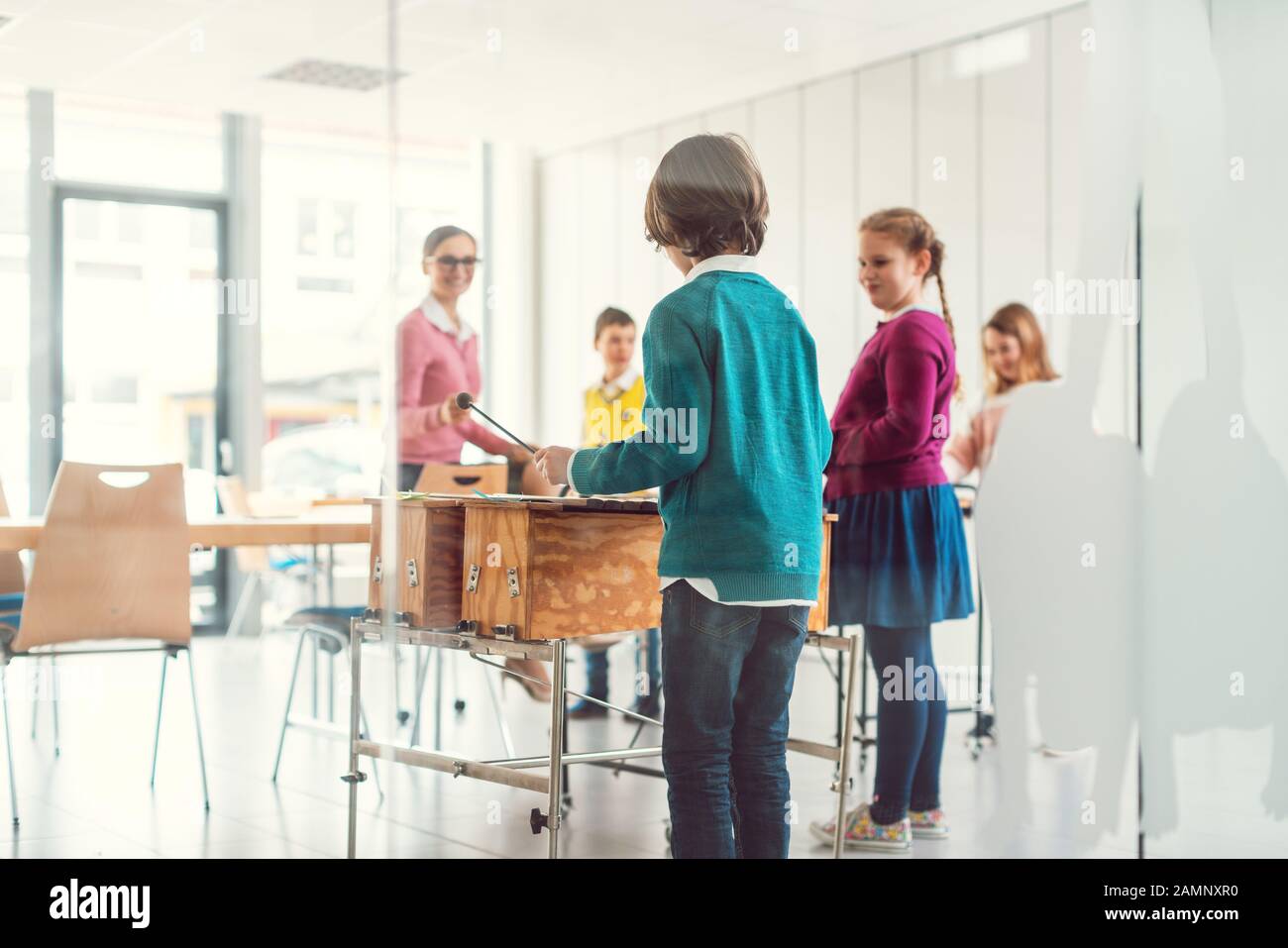 Insegnante di musica con studenti in classe sullo xilofono Foto Stock