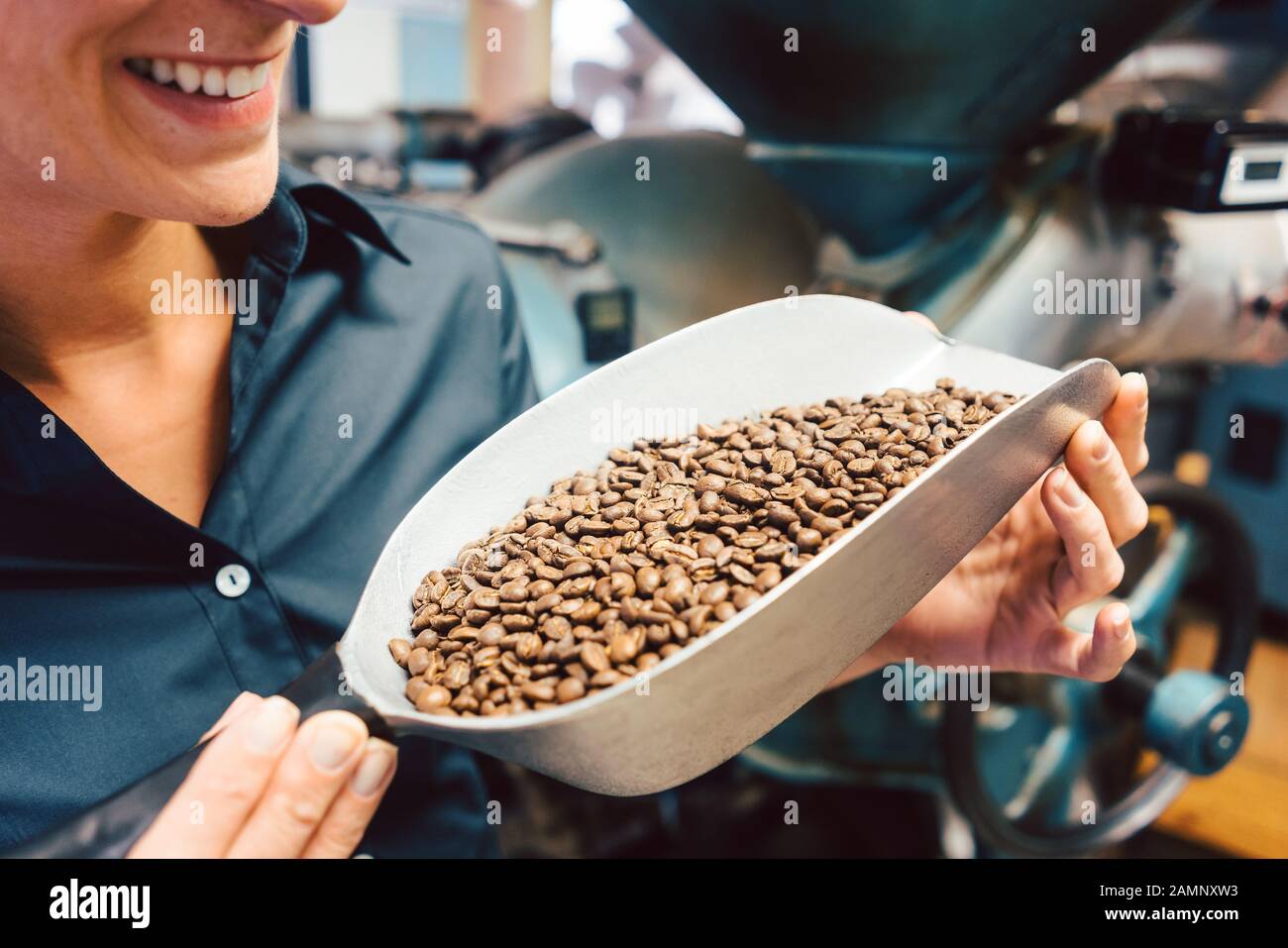 Donna in coffee roastery con chicchi freschi Foto Stock