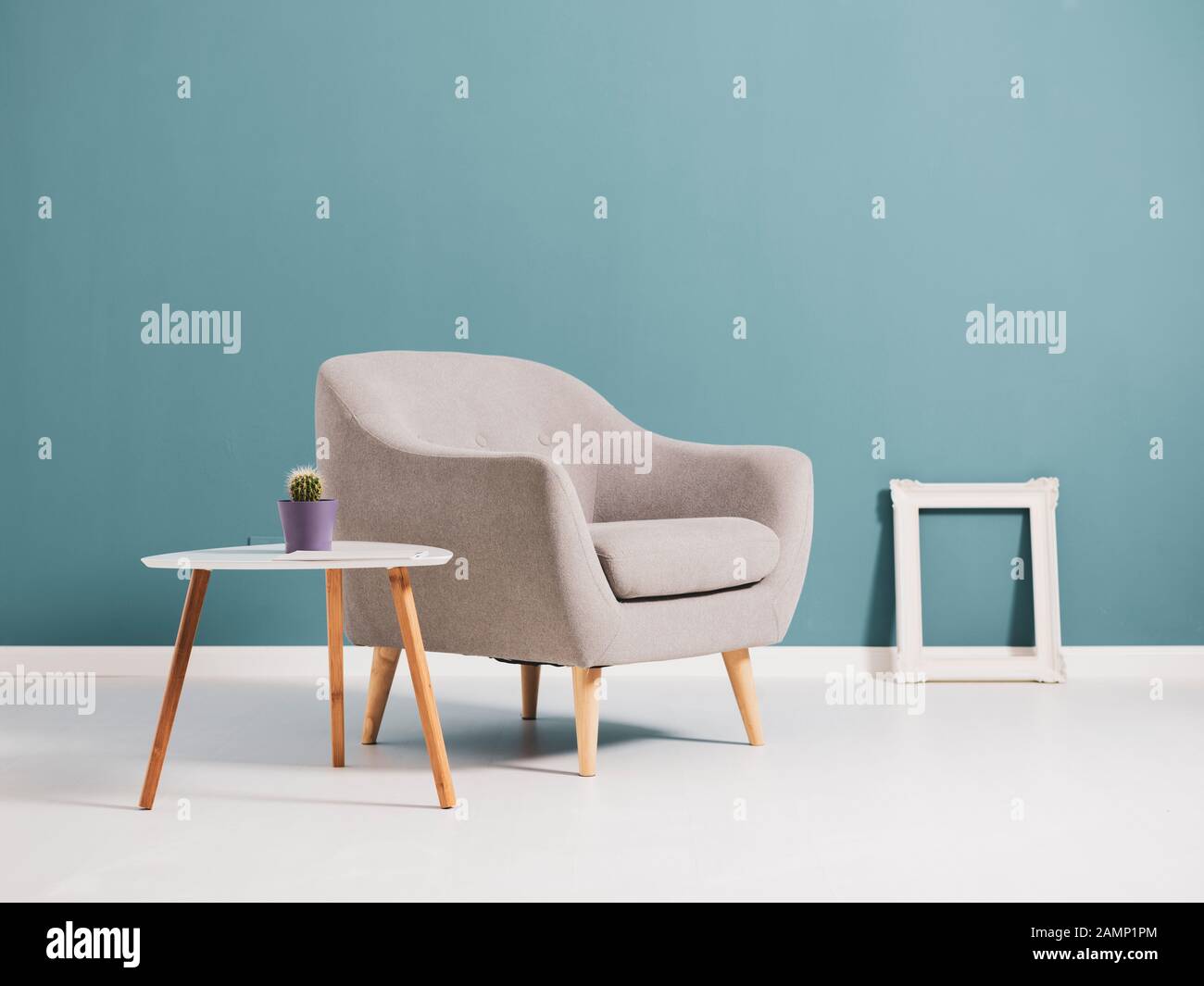 Interni soggiorno con arredamento minimalista in stile scandinavo e cornice vuota appoggiata al pavimento Foto Stock