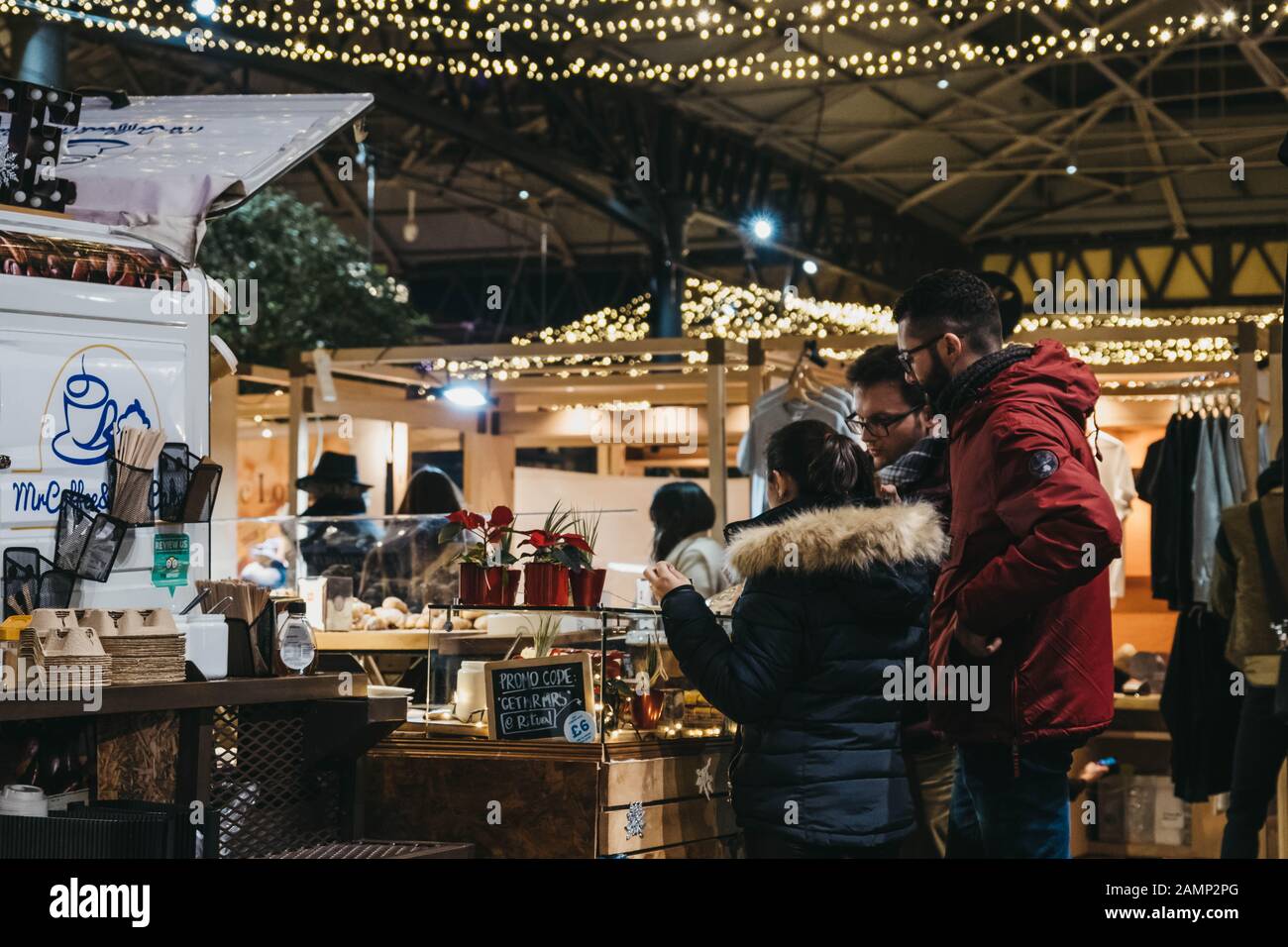 Londra, Regno Unito - 29 dicembre 2019: Persone in stallo alimentare nel mercato Spitalfields, una delle migliori strutture vittoriane del mercato di Londra con bancarelle che offrono f Foto Stock