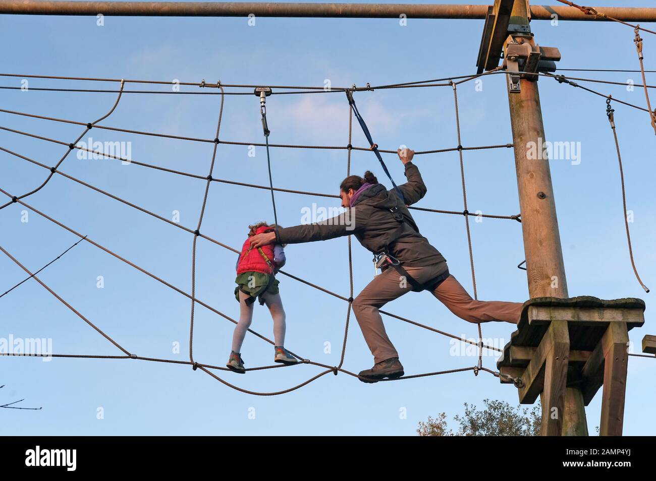 Un uomo guida un giovane bambino attraverso un telaio di arrampicata presso lo Zoo di Bristol Foto Stock