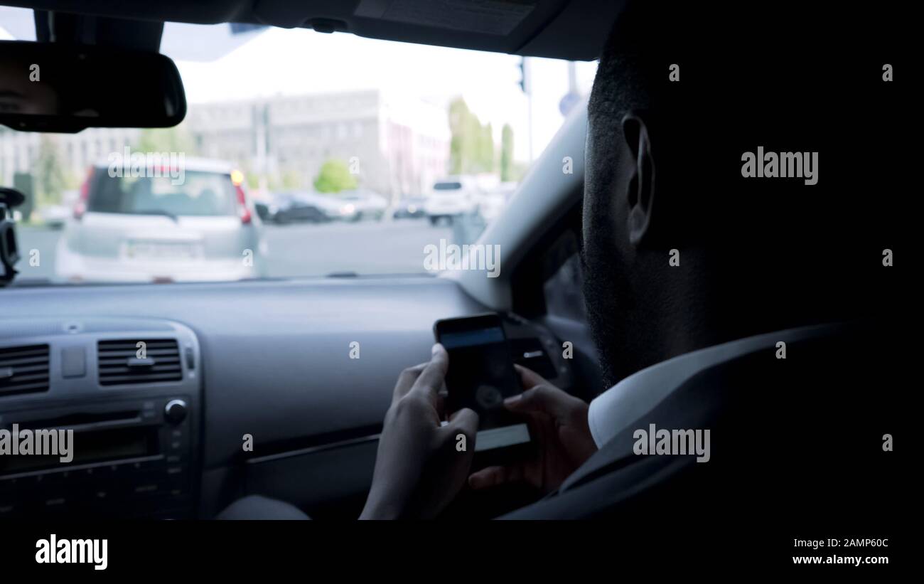 Uomo che sta per incontrare i partner, guardando attraverso le statistiche aziendali sul gadget Foto Stock