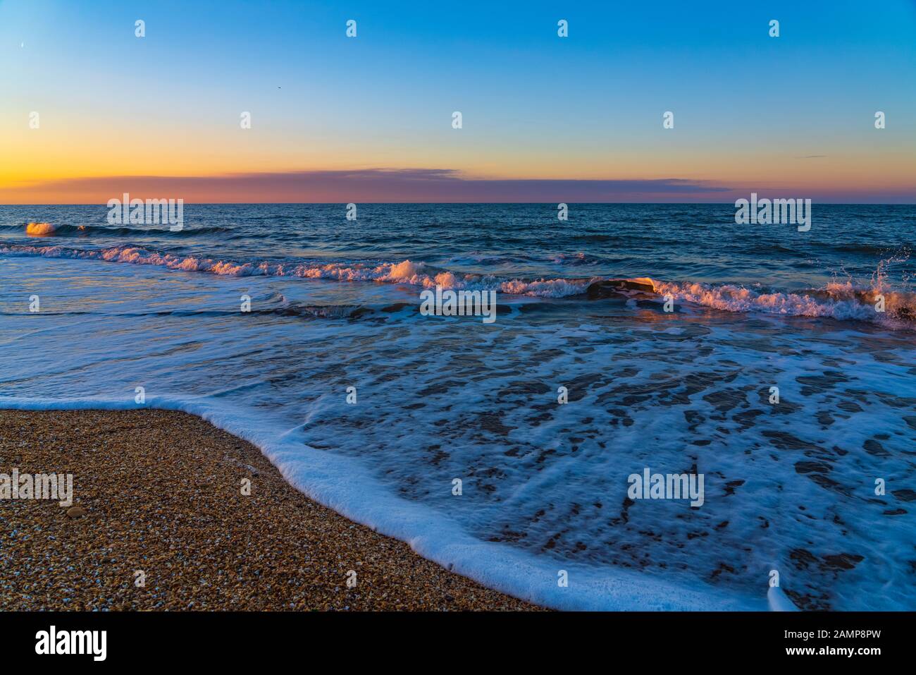 Spiaggia di mare nei colori del tramonto Foto Stock