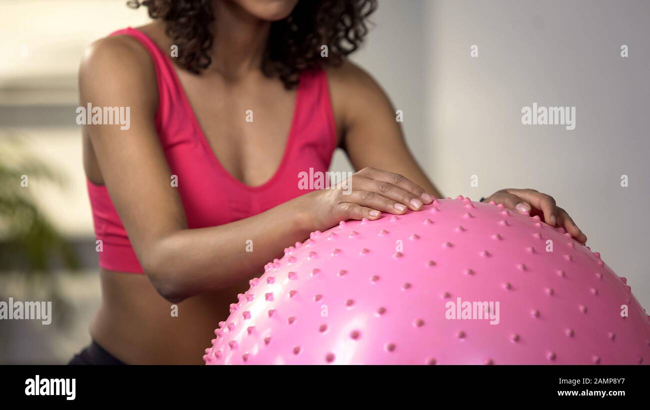 Giovane donna che fa esercizi con palla fitness, attività fisica, allenamento Foto Stock