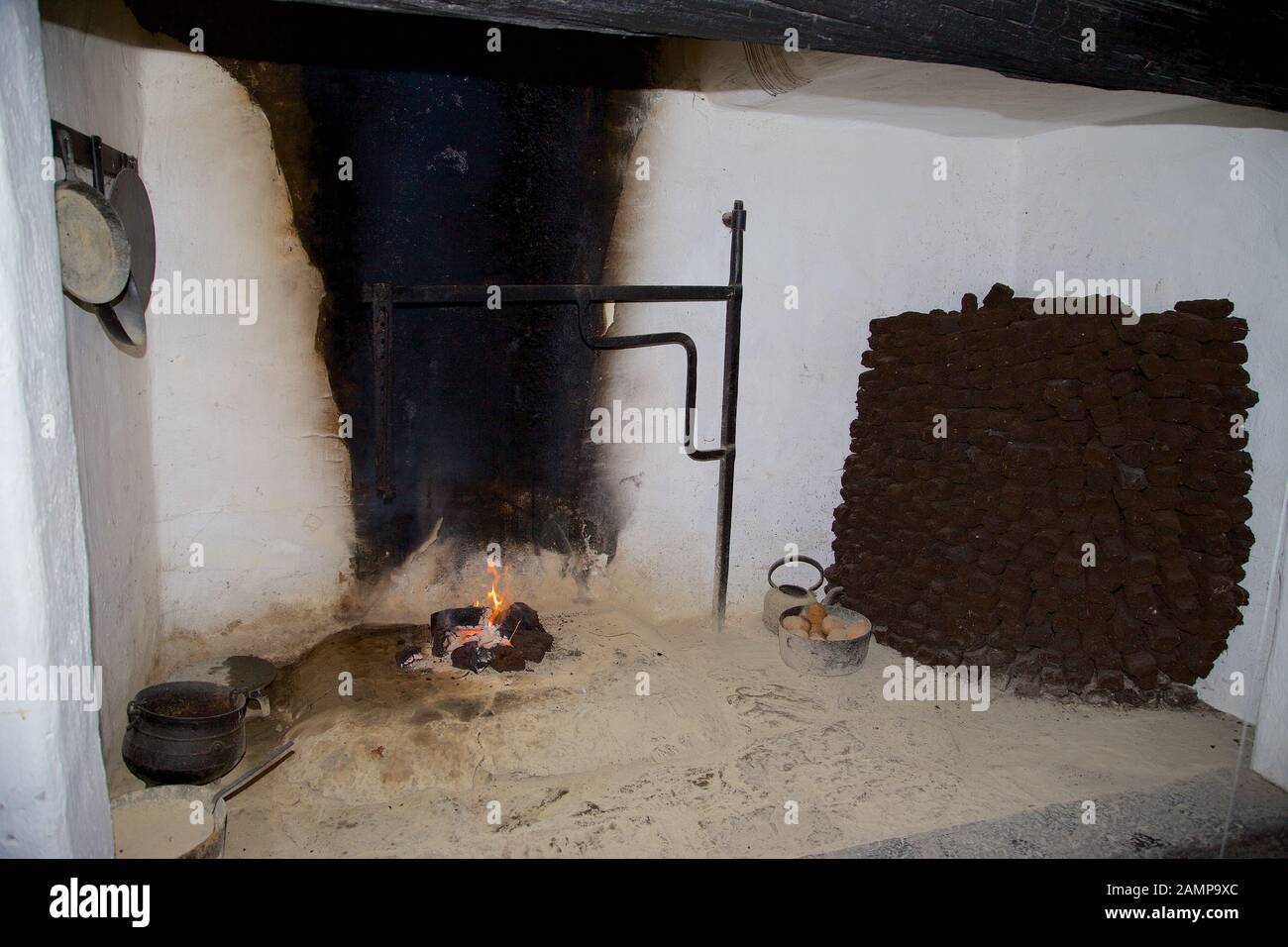 Un caminetto aperto in un tradizionale vecchio stile cottage irlandese. Una pila di manto erboso può essere visto sulla destra della foto. Foto Stock