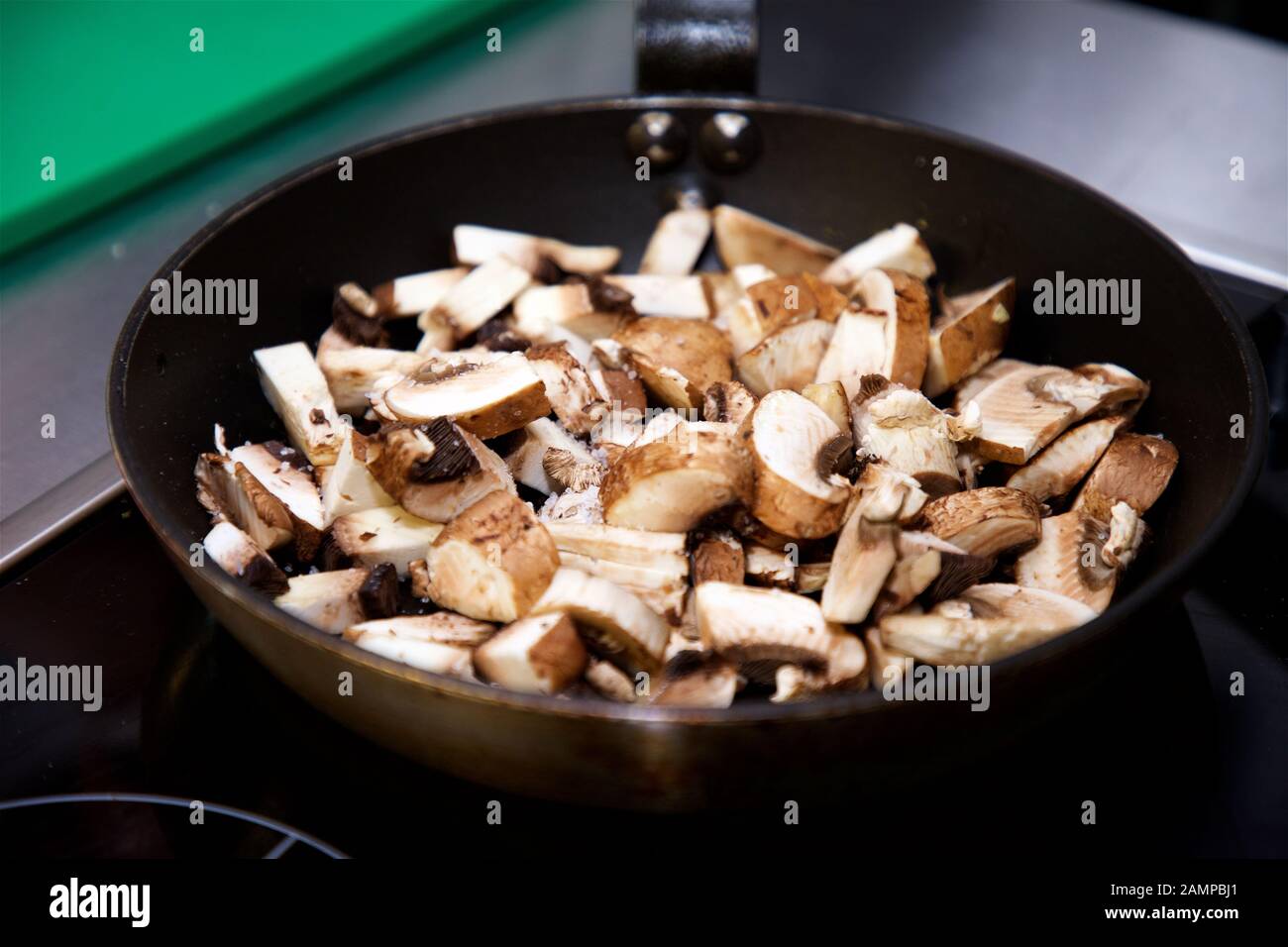 Sautéing funghi in padella. Foto Stock
