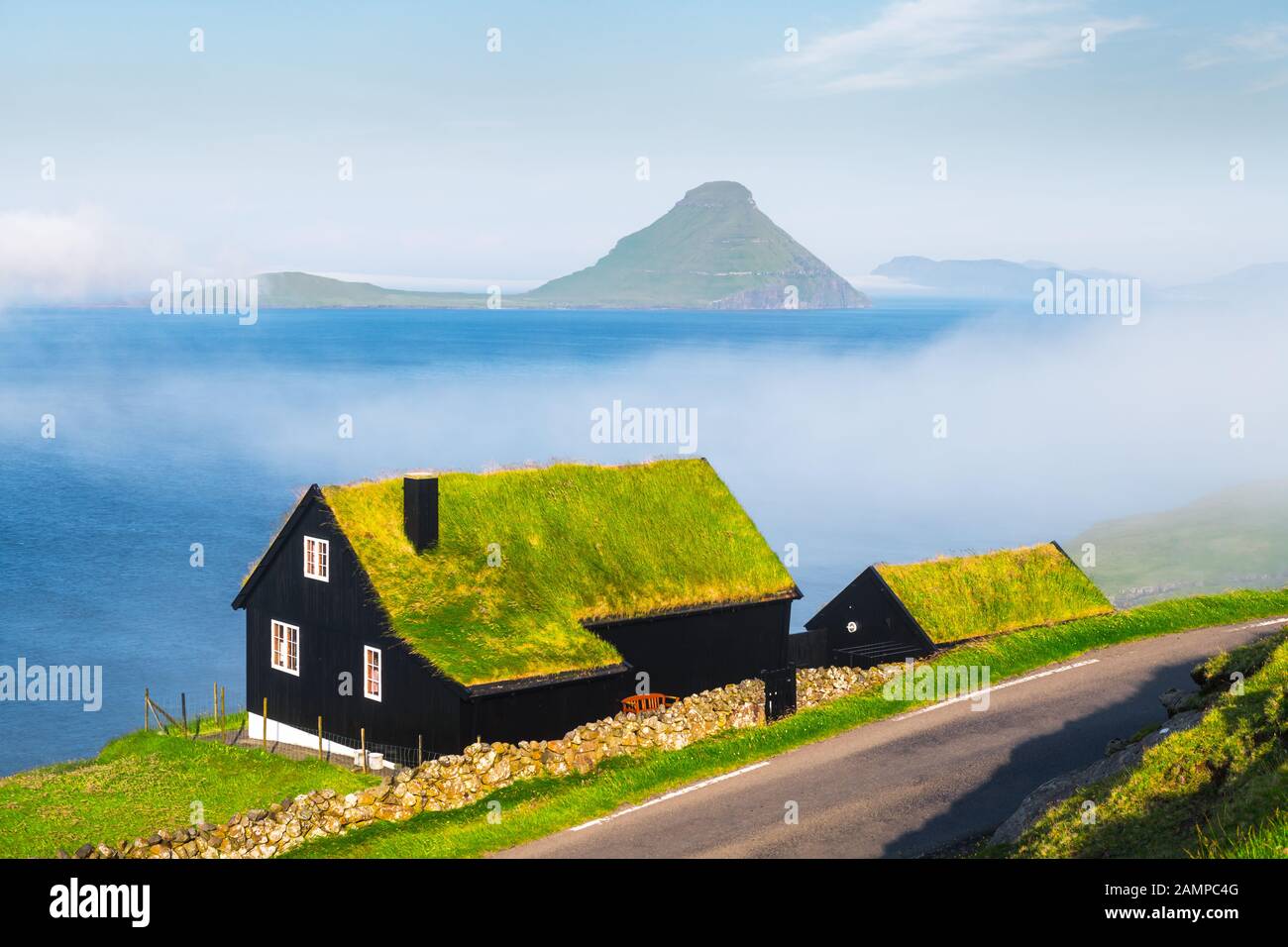 Mattinata nebbiosa vista di una casa con il tipico turf-top tetto di erba nel villaggio Velbastadur sull isola di Streymoy, isole Faerøer, Danimarca. Fotografia di paesaggi Foto Stock