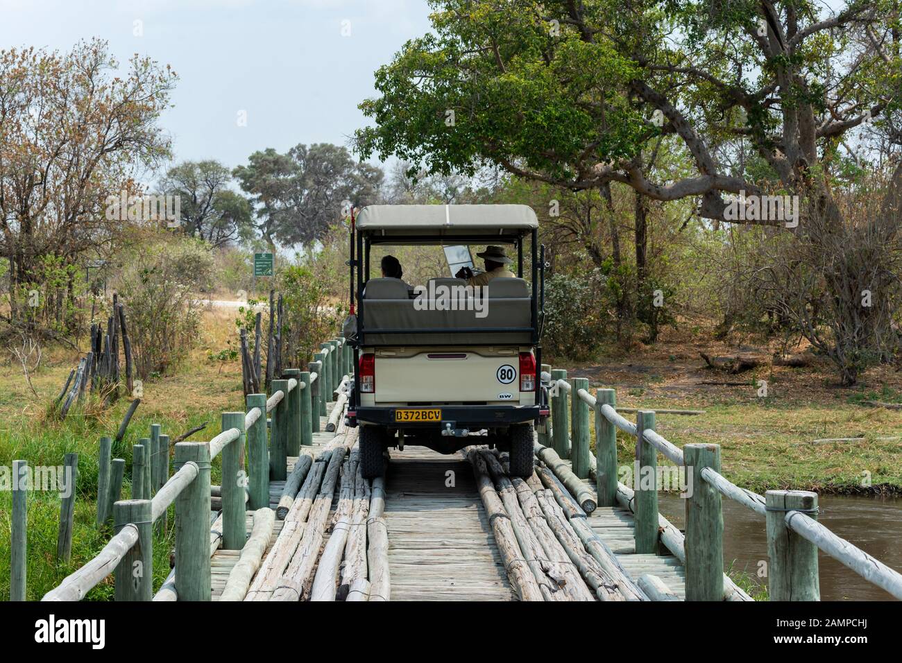 Safari veicolo attraversando ponte di legno sul fiume lasciando Moremi Game Reserve, Okavango Delta, Botswana, Africa del Sud Foto Stock