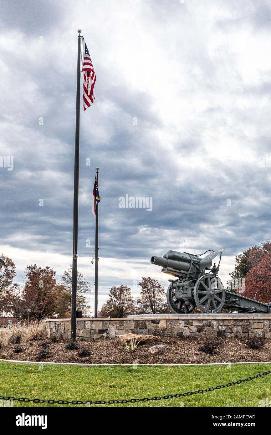 Hickory, NC, USA-22 NOV 2019: Un cannone catturato tedesco della seconda guerra mondiale si trova nella piazza della città, con bandiere di stato americane e NC in volo. Foto Stock
