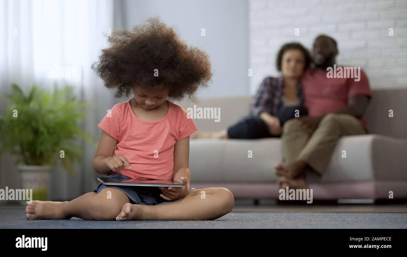 I genitori orgogliosamente osservando come la loro figlia che lavora sul tablet, bambino prodigio Foto Stock