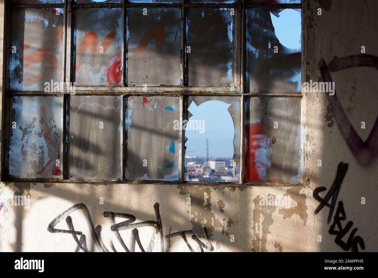 Decadimento urbano - finestre e graffiti rotti in un magazzino abbandonato a Dublino, Irlanda. Foto Stock