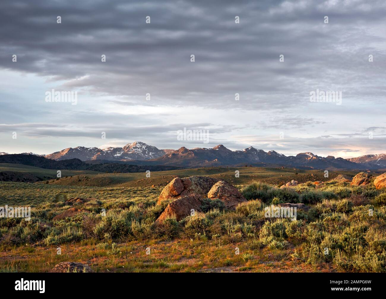 WY03957-00...WYOMING - il sole che si riscalda le nuvole e Wind River Range dal paese di alta prateria sopra il Big Sandy River. Foto Stock