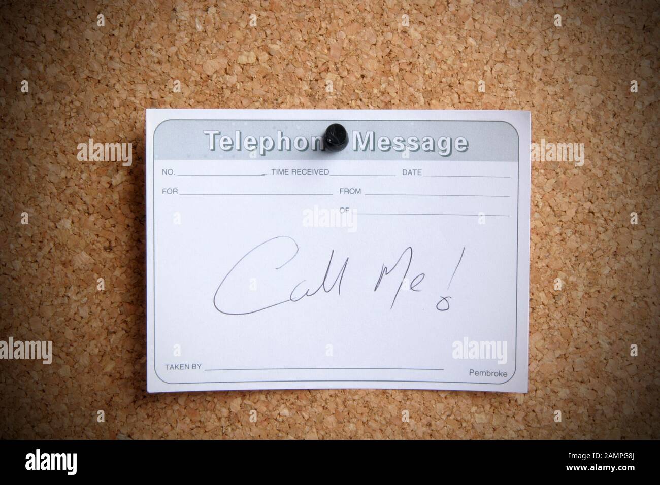 Una nota di chiamata scritta a mano appigliata su una bacheca. Foto Stock