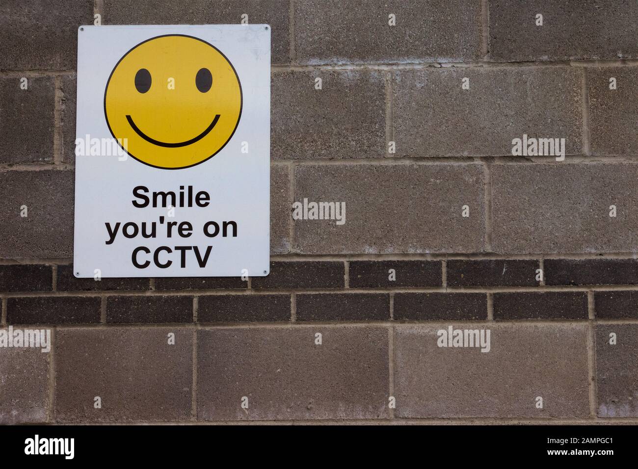 Segnale di avvertenza "sei in cctv" con un volto smiley. Foto Stock