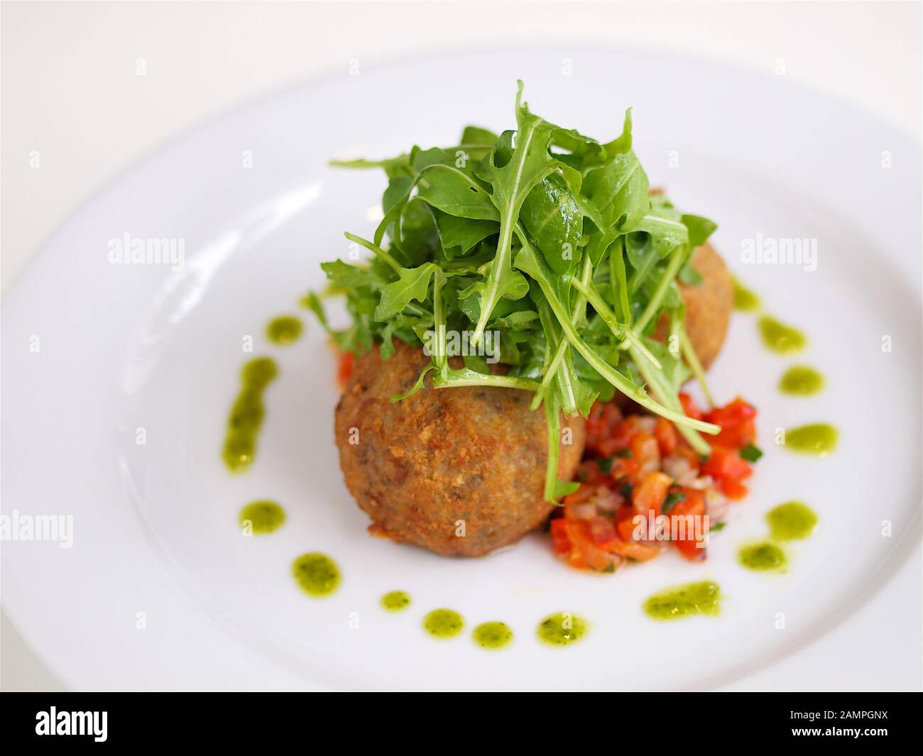 Fritti di formaggio di capra serviti con rucola e salsa di pomodoro. Foto Stock