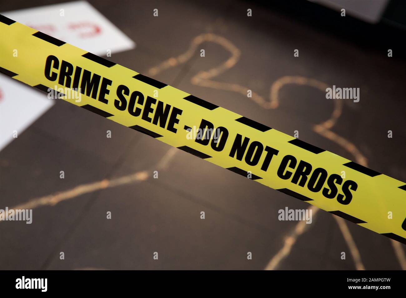 Simulazione della scena del crimine giallo con cordone di polizia di nastro e chalk contorno corpo. Foto Stock