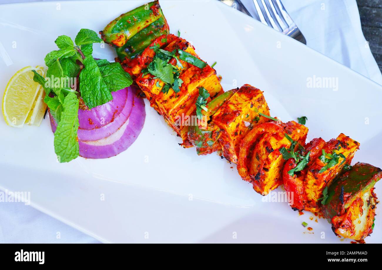 Un paneer tikka sizzler kebab piatto in un ristorante indiano Foto Stock