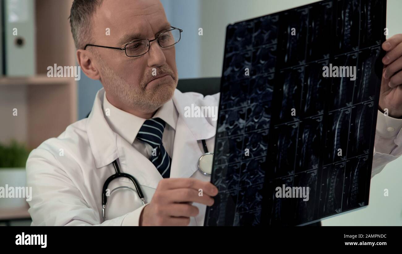 Il medico che studia i pazienti malati mri, trova danni nella vertebra cervicale, diagnostica Foto Stock