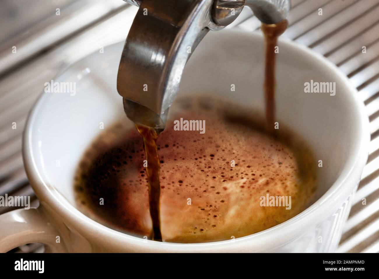 Il caffè espresso viene versato in una tazza da una macchina per il caffè Foto Stock