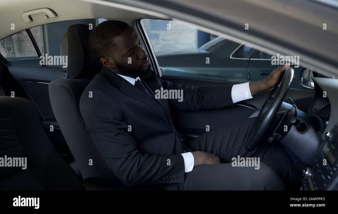 Un uomo d'affari stanco sconvolto seduto in auto, pensando a break-up, problemi Foto Stock