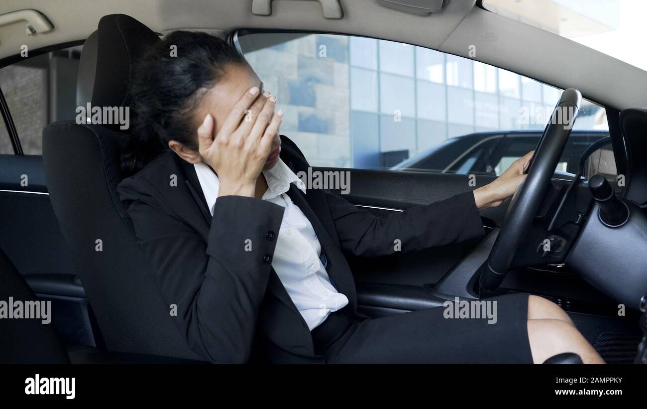 Donna d'affari stressata seduta in auto, che soffre di mal di testa, problemi Foto Stock