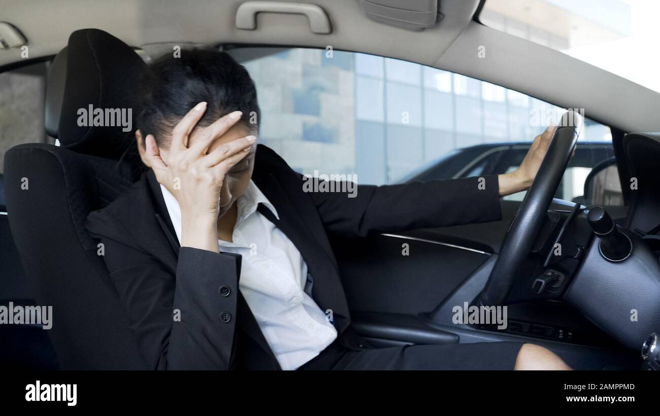 Depressa donna di affari seduta in auto, pensando al licenziamento, problemi Foto Stock