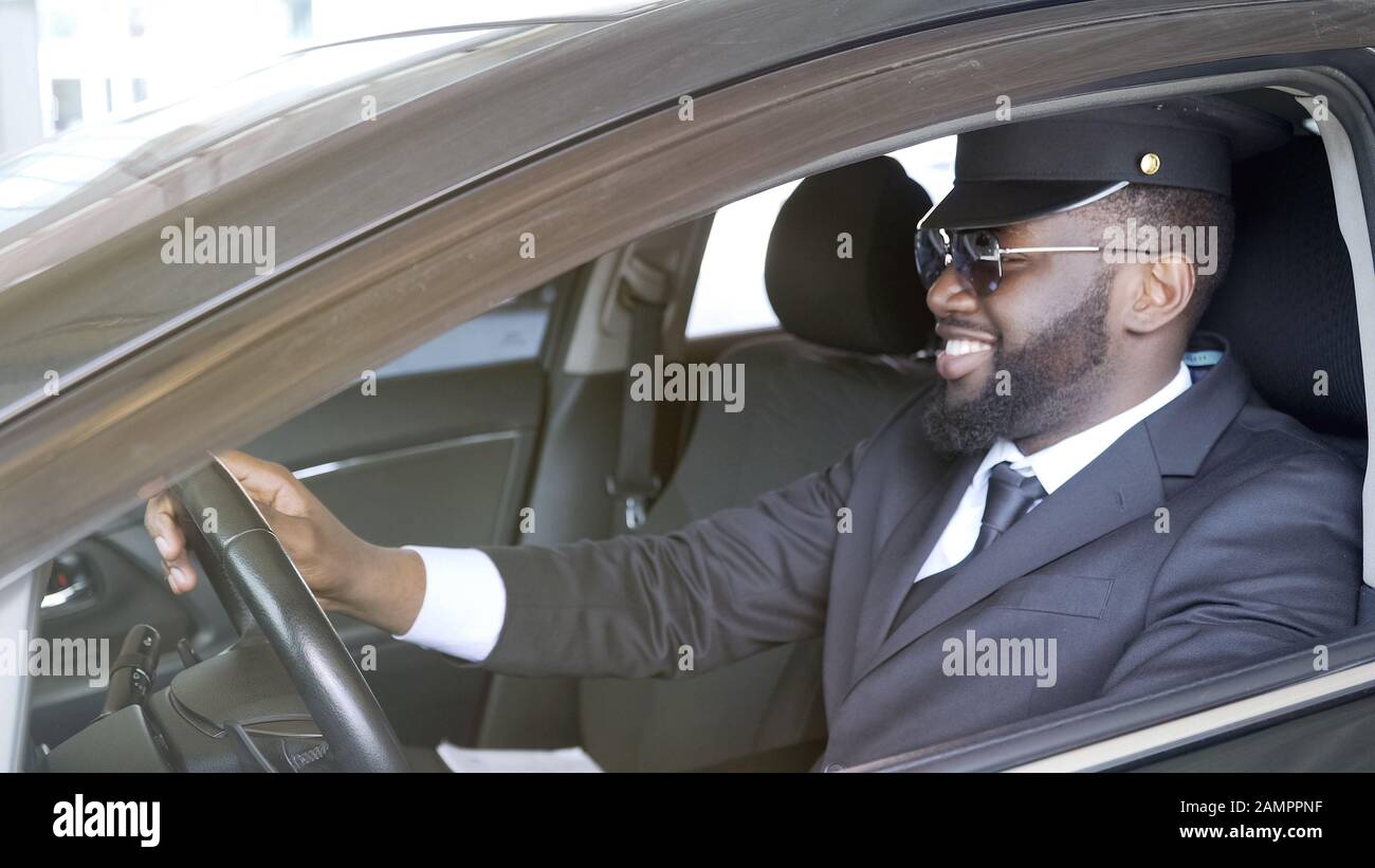 Sorridente autista d'affari seduto in un'automobile di lusso, servizio di trasporto Foto Stock