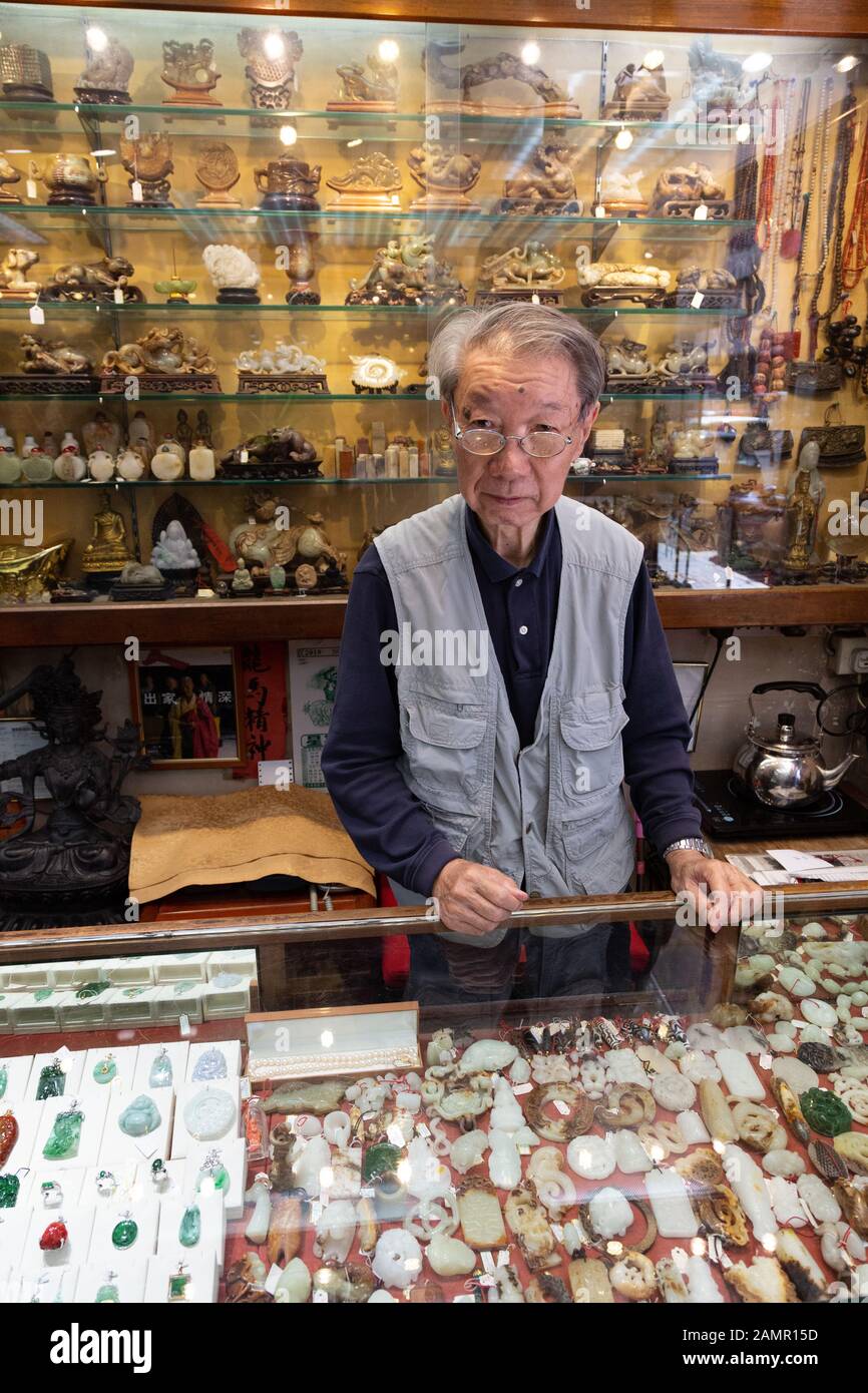 Hong Kong shop interno; un bottegaio dietro il contatore in un negozio di giada, Kowloon Hong Kong Asia Foto Stock