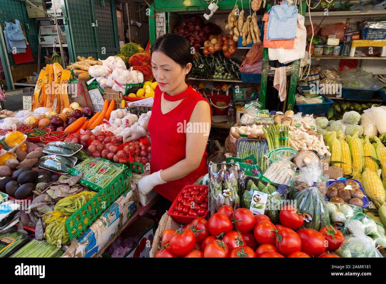 Mercato di Hong Kong - una giovane donna che ha stallato al suo frutteto e alla stalla di Veg, Bowring Street, Kowloon Hong Kong Asia Foto Stock