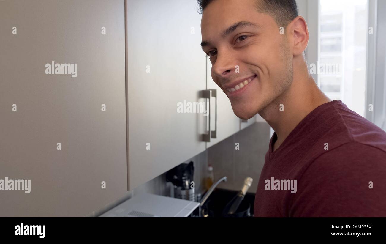 Ospitale proprietario della casa sorridente, incontrare gli ospiti durante la cucina in cucina, closeup Foto Stock
