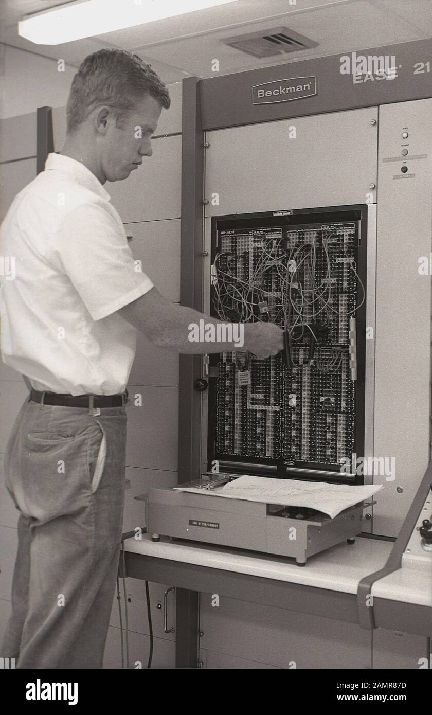 1960s, storico, giovane uomo che lavora sul cablaggio di un computer Beckman 'Ease' 2100, California, Stati Uniti. L'EASE (Electronic Analog and Simulation Equipment) è stato un computer analogico sviluppato per la prima volta nel 1950s dalla divisione Berkeley di Beckman Instruments di Richmond, California, per l'automazione e l'elaborazione dei dati nelle industrie scientifiche e aerospaziali. Foto Stock
