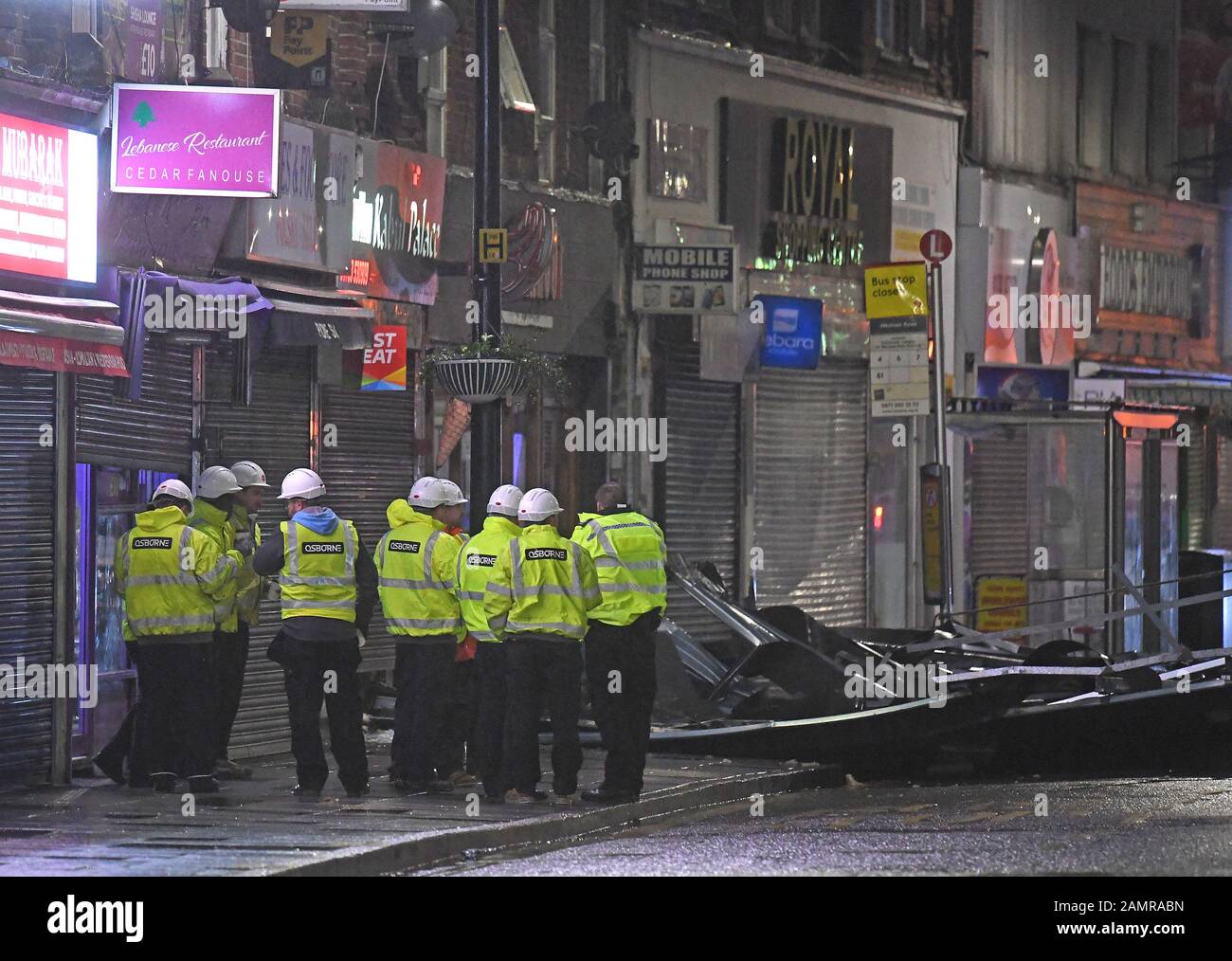 I lavoratori edili nella strada principale di Slough dopo che un tetto è stato soffiato fuori di un edificio sulla strada tra forti venti che hanno martoriato parti del Regno Unito. Foto Stock