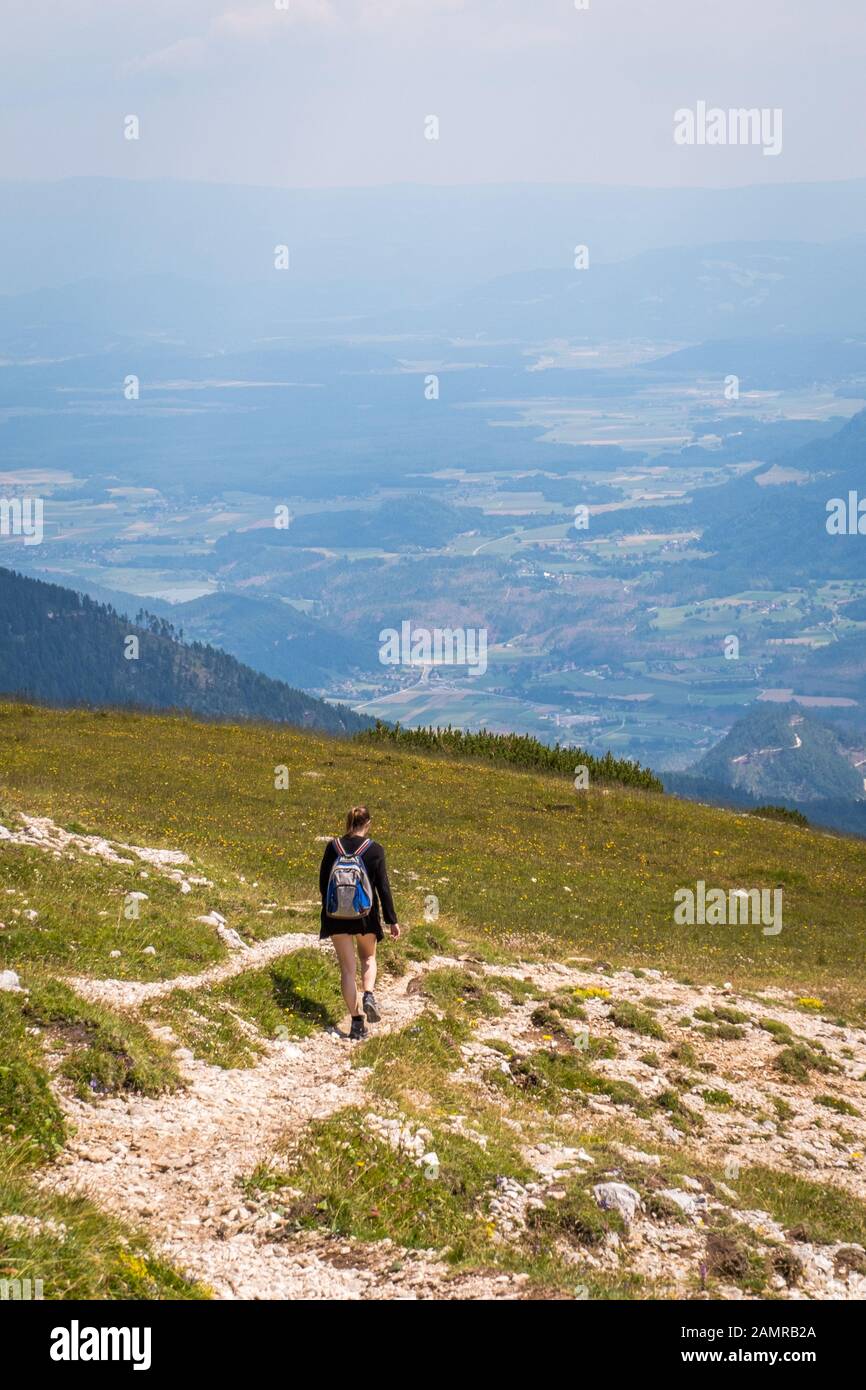 Donna ragazza escursionistica con vista dalla montagna Hochobir alla valle Jauntal in Carinzia, Austria Foto Stock