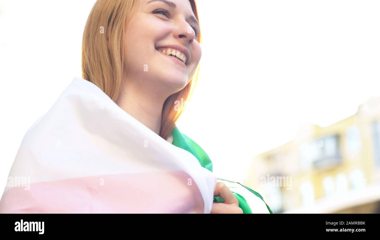 Donna sorridente in piedi in strada con bandiera nazionale, sentimenti patriottici, vacanza Foto Stock