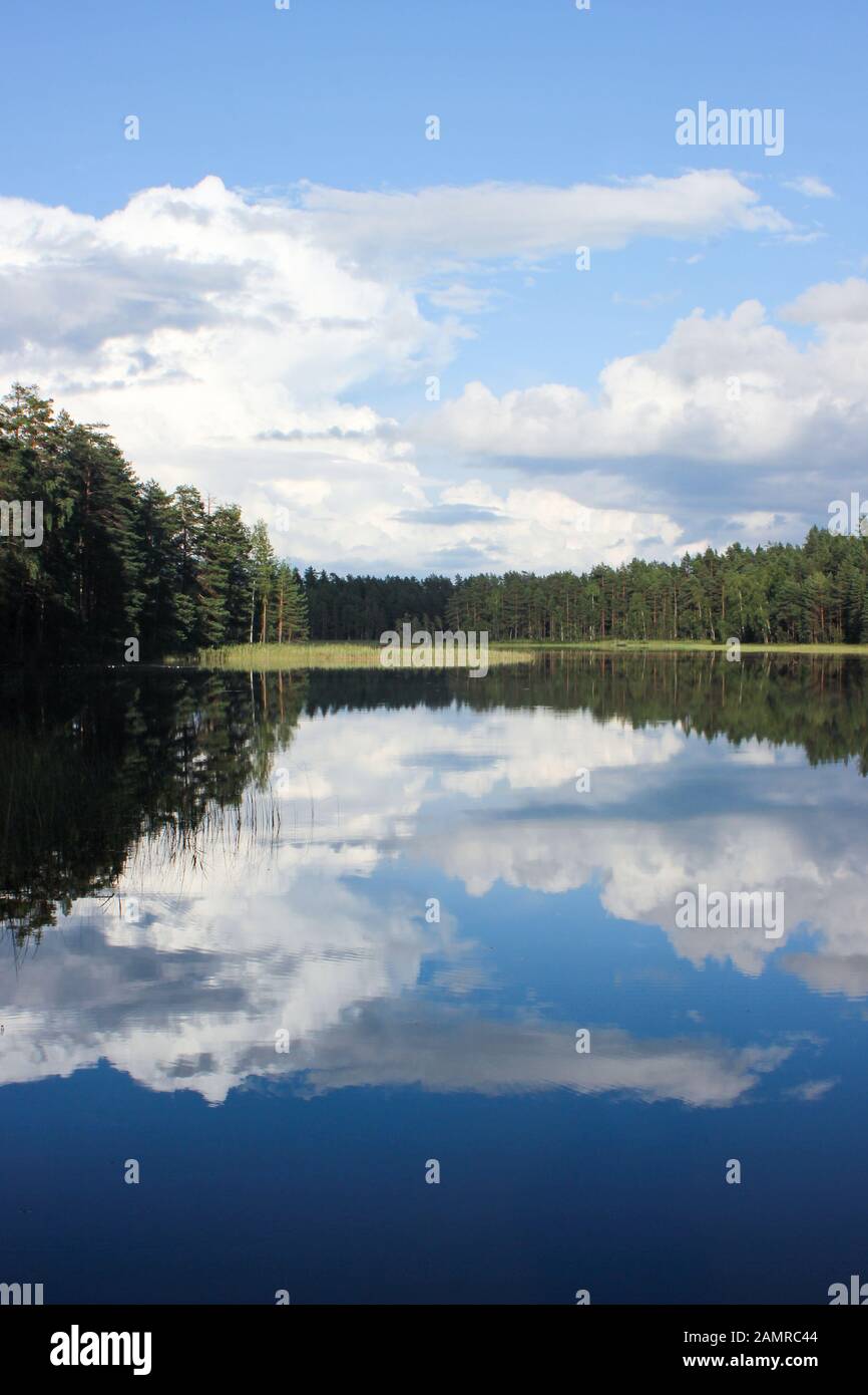 Vista panoramica sulle piccole e sereno Lago nordico con Cielo e nubi in riflessione Voikoski, Finlandia Foto Stock